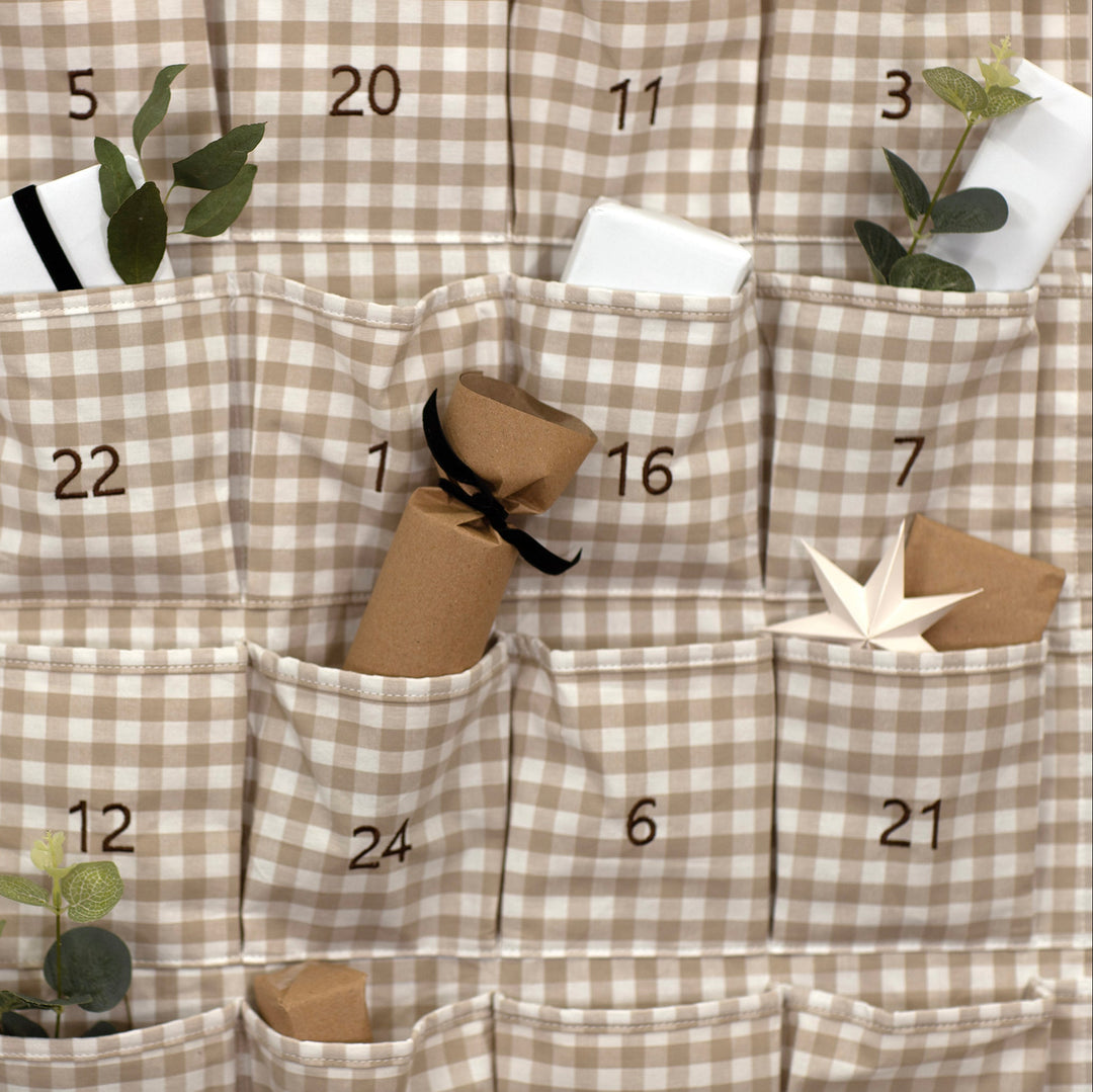 Checkered advent calendar with numbered pockets and small decorative items.