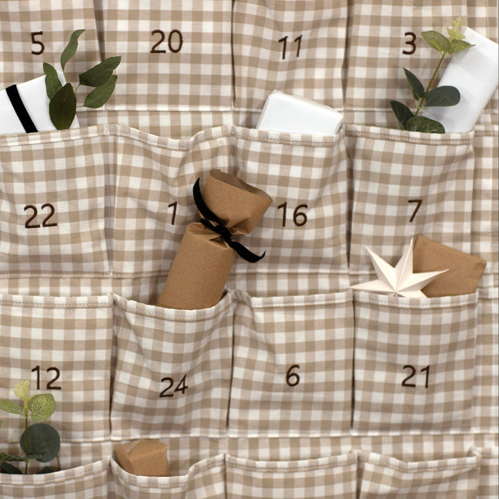 Checkered advent calendar with numbered pockets and small decorative items.