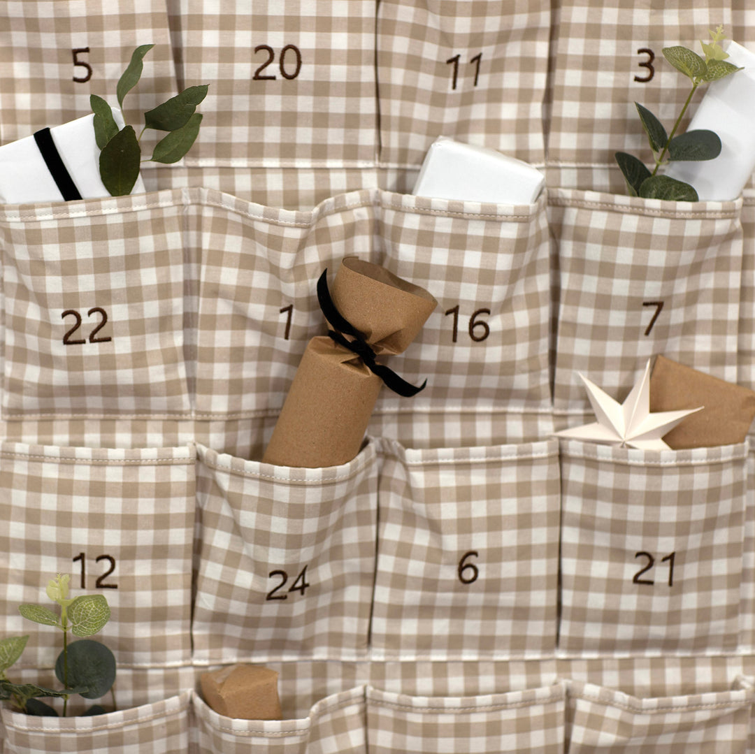 Checkered advent calendar with numbered pockets and small decorative items.