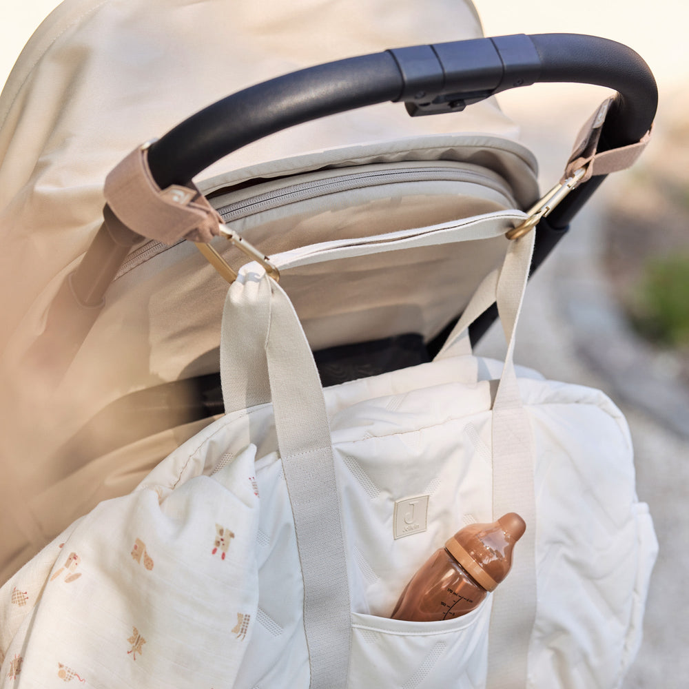 Baby in a stroller with a white blanket draped over it