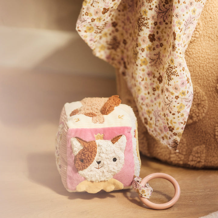 Small square pouch with cat design and keychain on a wooden surface