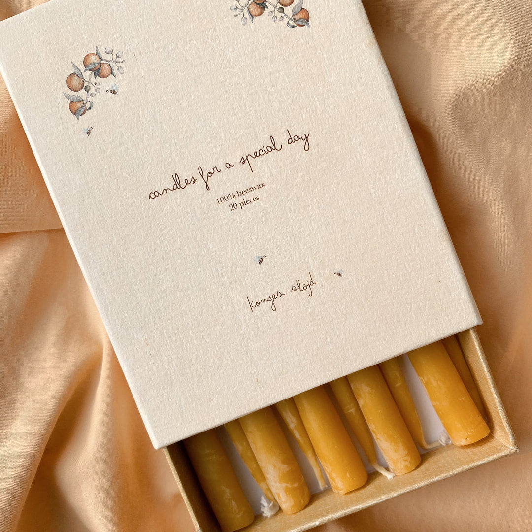 Box of candles with a decorative design on a beige fabric background