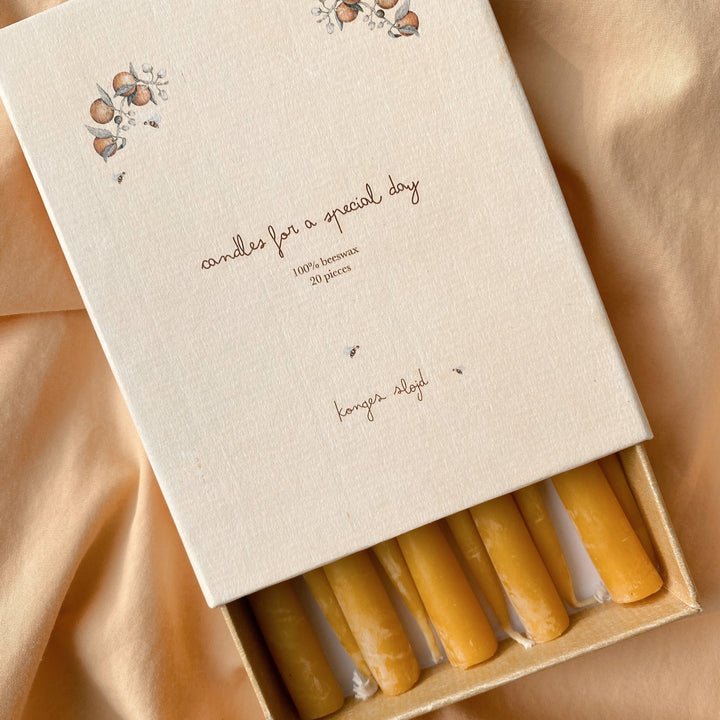 Box of candles with a decorative design on a beige fabric background