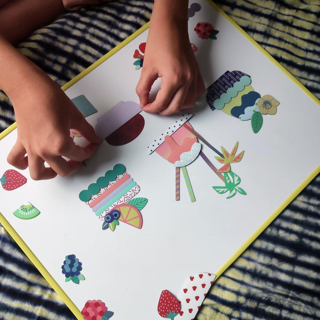 Child's hands interacting with colorful paper cutouts on a striped fabric background
